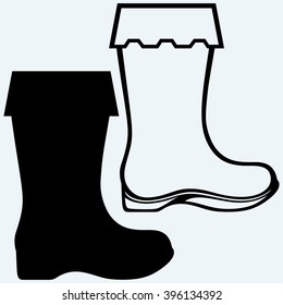 Old dirty boots. Isolated on blue background. Vector silhouettes
