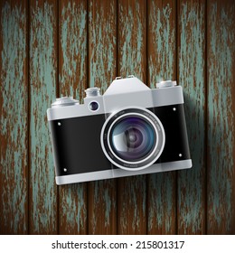 old film camera lying on a wooden surface