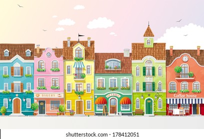 Old historical houses, shops and cafe at the city street with summer trees and flowers