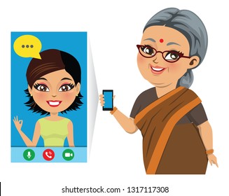 An Old Indian Woman Is Speaking On Phone With Her Daughter/ Grand Daughter Through A Video Call And Is Very Happy.