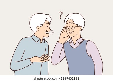 Old man talking to deaf friend who puts hand to ear and is having problems after hearing aid is broken. Elderly gray-haired man suffering from hearing disease needs help of otolaryngologist doctor 