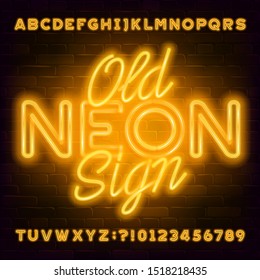 Old Neon Sign alphabet font. Yellow neon light letters and numbers on brick wall background. Stock vector typeface for your typography design.