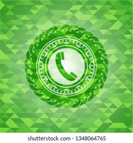 old phone icon inside green emblem with triangle mosaic background