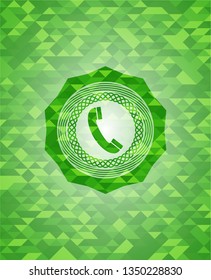 old phone icon inside green emblem with triangle mosaic background