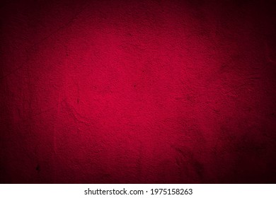Old red wall in spots, cracks, stains. Painted concrete wall in abstract grunge style. Grunge loft background texture for backgrounds, portraits, posters.