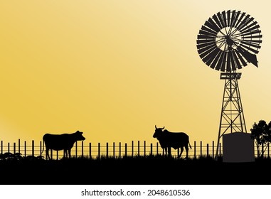 old style windmill with two cows silhouette fence and yellow background