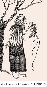 Old witch with a wreath stands under a tree