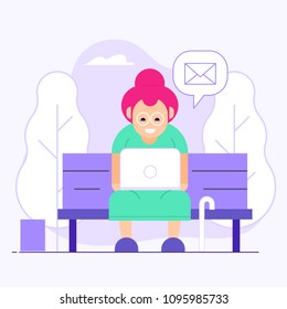 Old woman chatting on social media in public park concept. Granny sitting on bench and holding laptop on knees. Pensioner citizen online activities. Receiving mail or messages and web talking.