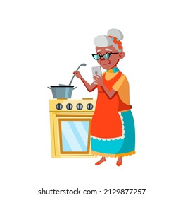Old Woman Cooking And Using Mobile Phone Vector. Latin Grandmother Searching Dish Recipe In Internet On Mobile Phone And Preparing Meal On Kitchen. Character Flat Cartoon Illustration