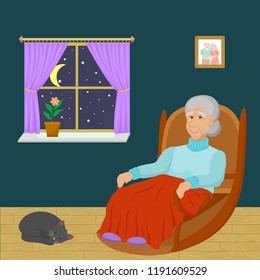 
Old Woman Sitting In A Rocking Chair In A Room At Night Time  And Sleeping Cat