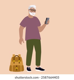 Older bearded man wearing eyeglasses holding a smartphone in right hand and looking at it. Next to him on the ground is a backpack. Active seniors travel concept