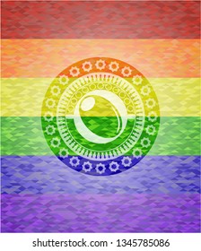 olive icon inside emblem on mosaic background with the colors of the LGBT flag