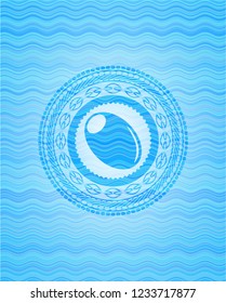 olive icon inside sky blue water wave badge.