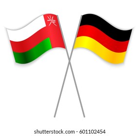 Omani and German crossed flags. Oman combined with Germany isolated on white. Language learning, international business or travel concept.