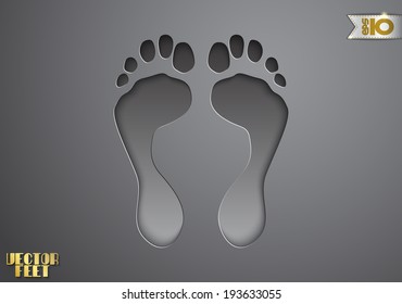 On a gray background feet cut from paper