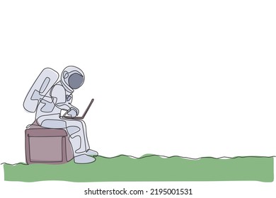 One continuous line drawing spaceman on spacesuit siting on chair while typing in laptop. Astronaut business office with deep space concept. Dynamic single line draw design vector graphic illustration