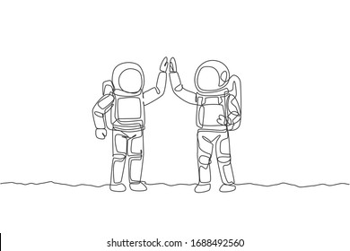 One continuous line drawing of two young happy astronauts giving high five gesture to celebrate teamwork in moon surface. Spaceman concept. Dynamic single line draw design vector graphic illustration