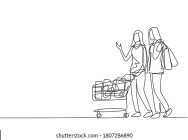 One Continuous Line Drawing Two Happy Friend Women Pushing Trolley And Holding Paper Bags When Shopping Together At Super Market. Shopping In Hypermarket Concept. Single Line Draw Design Illustration