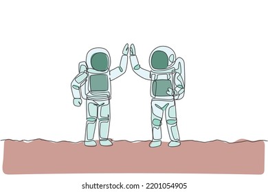 One continuous line drawing of two young happy astronauts giving high five gesture to celebrate teamwork in moon surface. Spaceman concept. Dynamic single line draw design vector graphic illustration