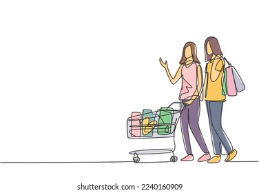 One continuous line drawing two happy friend women pushing trolley and holding paper bags when shopping together at super market. Shopping in hypermarket concept. Single line draw design illustration