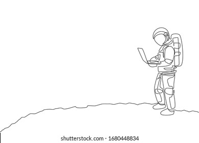 One continuous line drawing of young spaceman on spacesuit standing while typing in moon surface. Astronaut business office with deep space concept. Dynamic single line draw design vector illustration