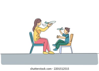 Una línea contínua de una joven madre y su hija sentadas en una silla y jugando al juguete del avión juntos en casa. Feliz concepto de paternidad familiar. Ilustración vectorial de diseño de líneas simples