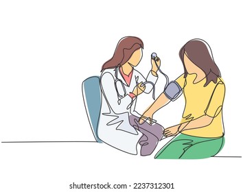 One continuous line drawing of young female doctor checking patient pulse rate and blood tension using tensiometer. Medical health care treatment concept single line draw design vector illustration