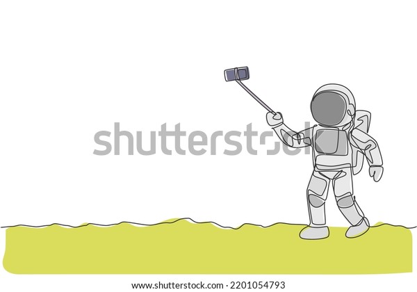 One continuous line drawing of young happy
astronaut doing selfie shot in moon surface with smartphone. Space
man deep space concept. Dynamic single line draw graphic design
vector illustration