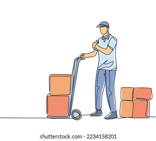 Un dibujo de una línea de un joven repartidor da gestos de aprobación hacia arriba mientras se carga el paquete de caja de cartón con carro al cliente. Concepto de servicio de entrega. Ilustración vectorial de dibujo de línea continua