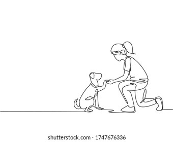 One line drawing of young happy girl handshaking her cute dog. Friendship about human and pet animal concept. Trendy continuous line drawing graphic vector illustration