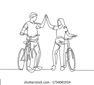 One line drawing of young happy couple male and female take a walk with bicycle at outfield park and giving high five gesture. Relationship concept continuous line draw design vector illustration