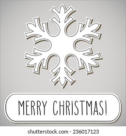One paper cut snowflake and hand written Christmas greetings in a frame.