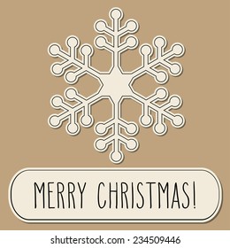 One paper snowflake and hand written Christmas greetings over brown background.