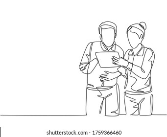 One single line drawing of two young male and female workers watching stock movements on tablet together at the office. Stockbroker concept continuous line draw design graphic vector illustration