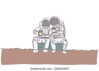 One single line drawing two young happy astronauts sitting while drinking coffee together in moon surface graphic vector illustration. Cosmonaut outer space concept. Modern continuous line draw design