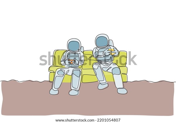 One single line drawing two young happy astronauts
siting on sofa and playing video game in moon surface graphic
vector illustration. Cosmonaut outer space concept. Modern
continuous line draw
design