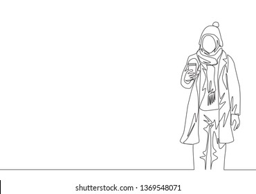 One single line drawing of young attractive happy muslimah wear beanie hat and hold coffee cup. Beauty Asian woman model in trendy hijab fashion concept continuous line draw design vector illustration