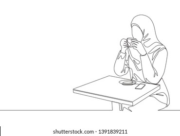 One single line drawing of young beauty female muslimah worker enjoying drink a cup of coffee at coffee shop. Islamic clothing hijab and veil concept. Continuous line draw design illustration