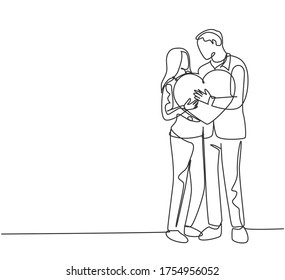 One single line drawing of young happy couple man and woman holding heart shape pillow and smiling each other. Romantic marriage love concept continuous line draw design graphic vector illustration