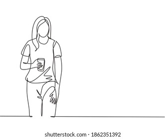 Un dibujo de una sola línea de una joven estudiante universitaria de pie con una camisa casual sosteniendo una taza de café. Diseño de té de secado contínuo trazado de línea vector gráfico ilustración de diseño