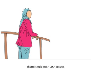 One single line drawing of young happy muslimah wearing head scarf and standing at fence. Beautiful Asian woman model in trendy hijab fashion concept continuous line draw design vector illustration