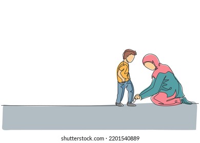 One single line drawing of young Islamic mom help her son to tie shoelace before go to the school vector illustration. Happy Arabian muslim family parenting concept. Modern continuous line draw design