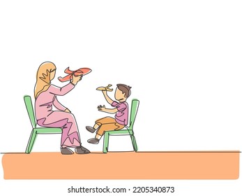 One Single Line Drawing Of Young Arabian Mom And Son Playing Airplane Toy Together At Home Vector Illustration. Happy Islamic Muslim Family Parenting Concept. Modern Continuous Line Draw Design