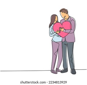 One single line drawing of young happy couple man and woman holding heart shape pillow and smiling each other. Romantic marriage love concept continuous line draw design graphic vector illustration