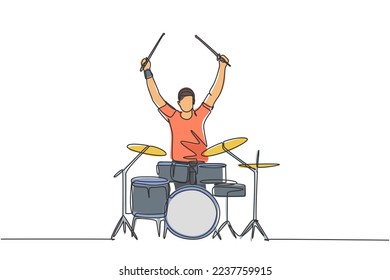 One single line drawing of young happy male drummer raise drumstick up while play drum set on music concert stage. Musician artist performance concept continuous line draw design vector illustration