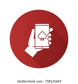 Online casino flat design long shadow glyph icon. Hand holding smartphone with spade card suit sign. Vector silhouette illustration