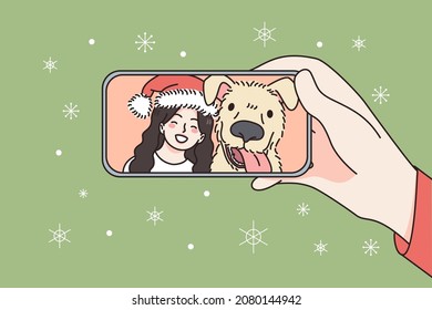 Online Christmas and New Year celebration concept. Human hand holding smartphone with smiling girl and dog in Santa hat celebrating and greeting online vector illustration 