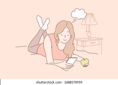 Online communication, social media or network concept. Young woman or girl laying on bed at home eating apple and chatting online using smartphone. Watching videos. Social media, network communication