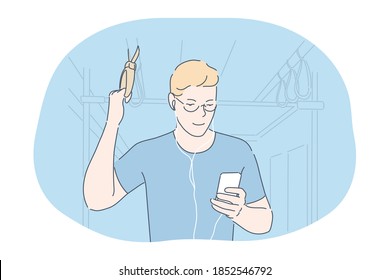 Online communication in transport concept. Smiling teen boy standing in subway or bus with smartphone, chatting, listening to music or watching movie online in earphones and looking at screen 