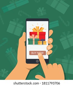 Online shopping for christmas gifts. Eshop of holiday presents in mobile phone. Hand holds phone with online shopping app for christmas